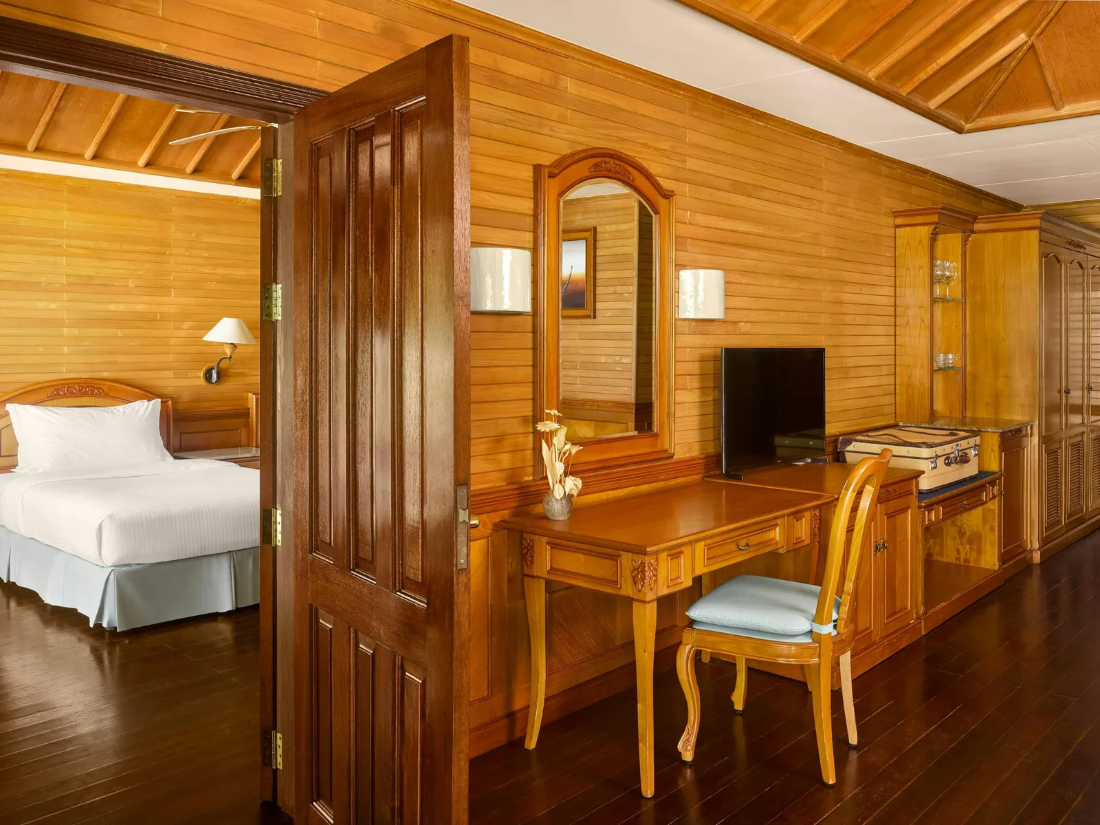 Inside a 2-bedroom Family Beach Villa: the open door between the 2 bedrooms, the desk and the timber walls.