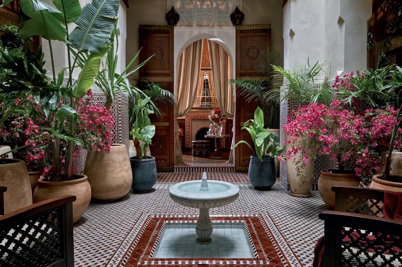 A riad patio with its fountain, pots of bougainvillea and zellige