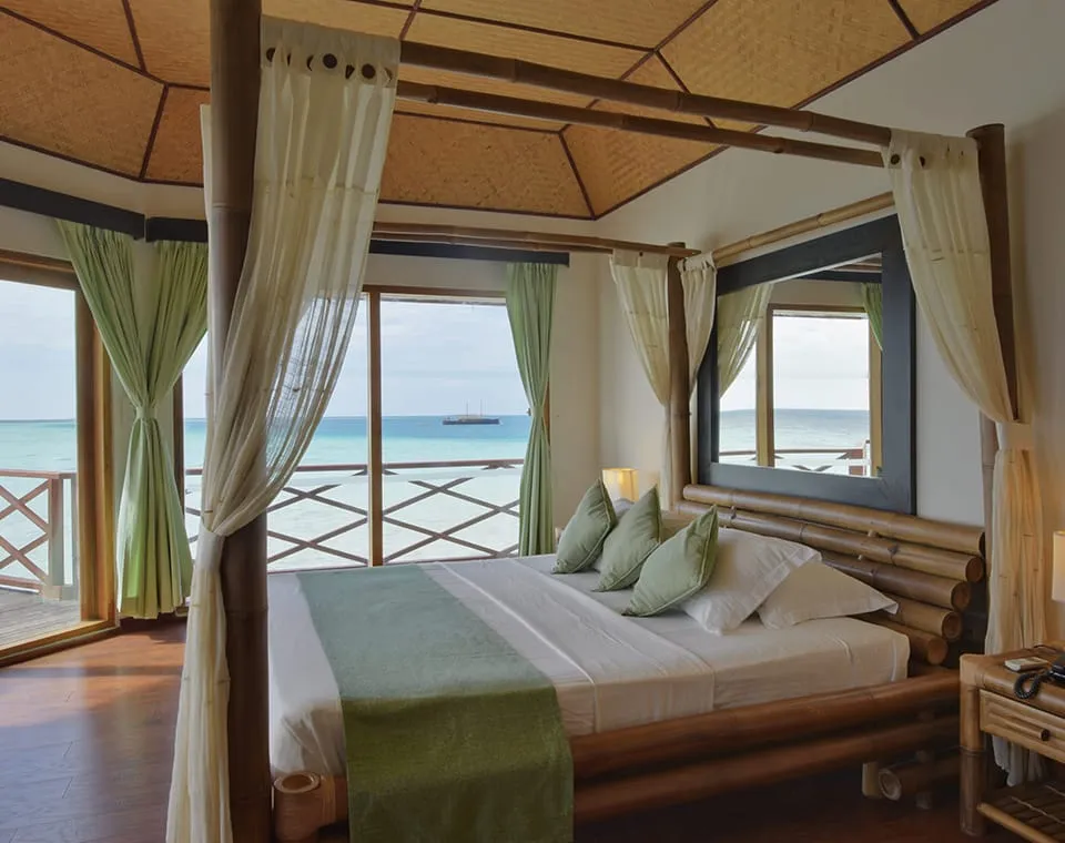 The bedroom with its four-poster bed and overwater terrace.