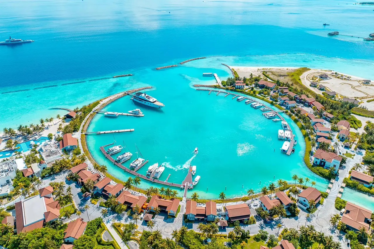 The CROSSROADS marina from above, yachts at their moorings and red roofs round the basin