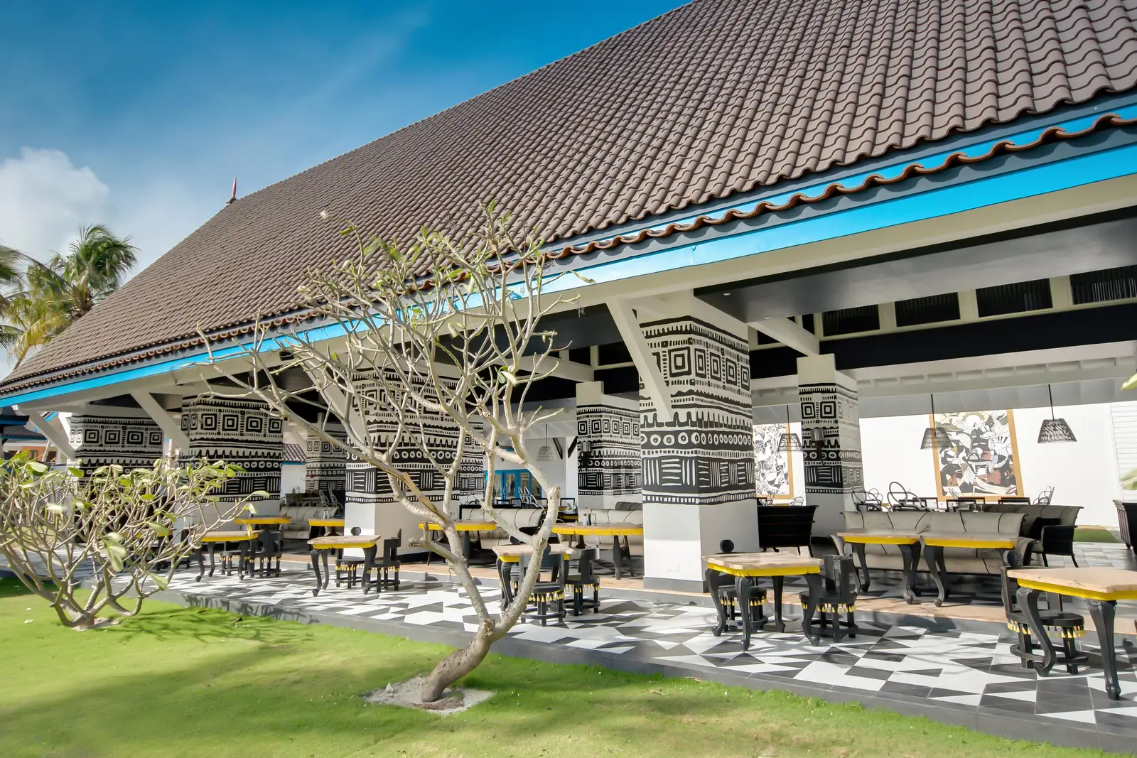 Miss Olive Oyl’s pavilion, its columns painted in black and white patterns and yellow tables under the roof
