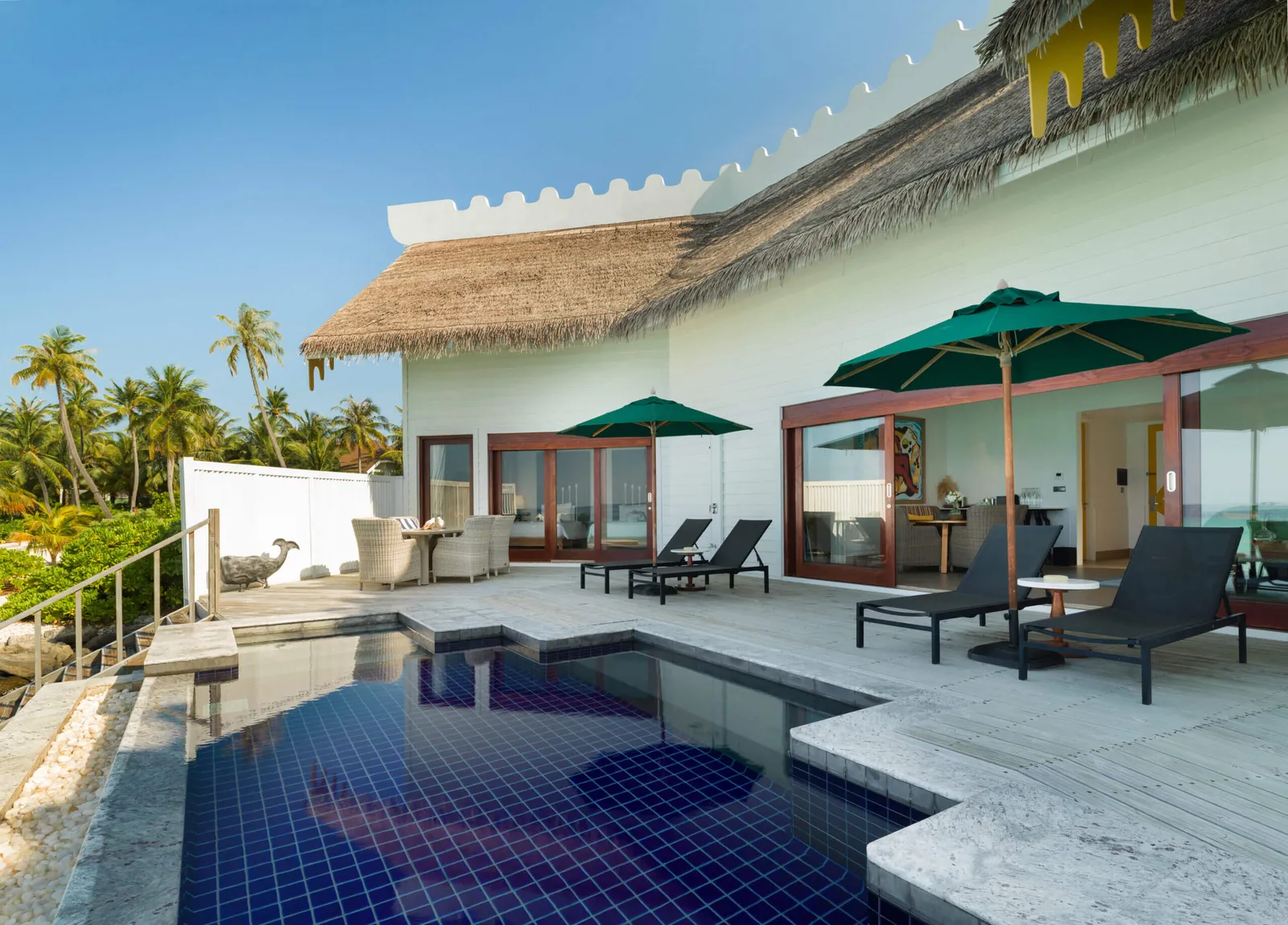 The 2-Bedroom Overwater Villa with Pool: its dark-blue pool, loungers and parasols on the deck