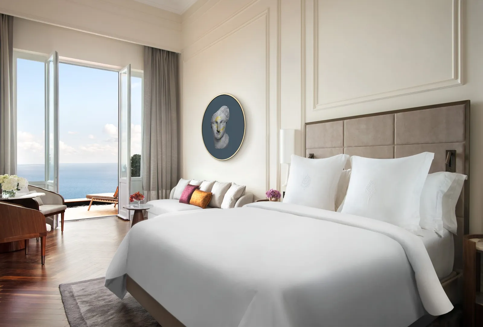 Bed and tall windows in a Sea-View Studio Suite with Plunge Pool