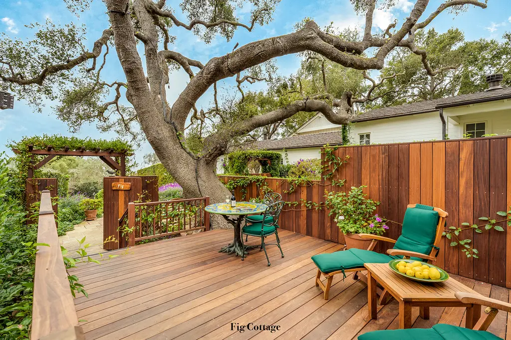Fig: the wooden deck under a great gnarled oak, with a small table, green loungers and a bowl of lemons.