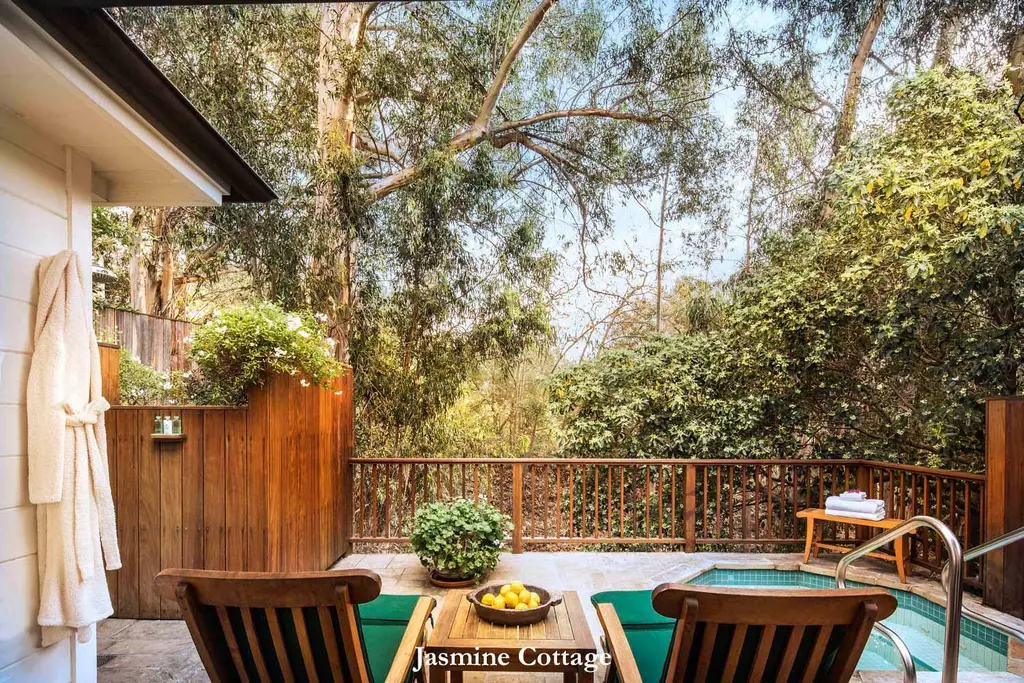 Jasmine: the deck among the trees, with 2 loungers, the sunken spa and a robe hanging by the door.