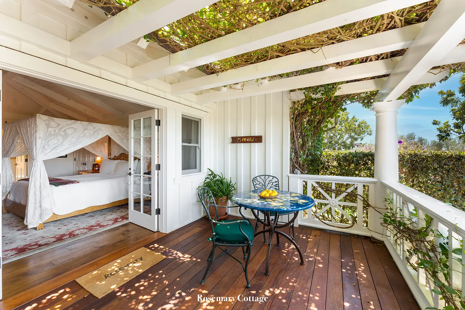 Rosemary: the white porch with a tiled table and, through the French doors, the canopy bed.