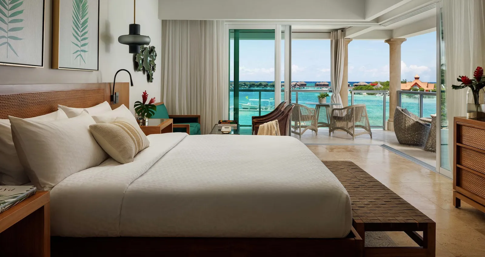 Official image: a bedroom with a wide bed and glazed doors to the balcony, facing the private island.
