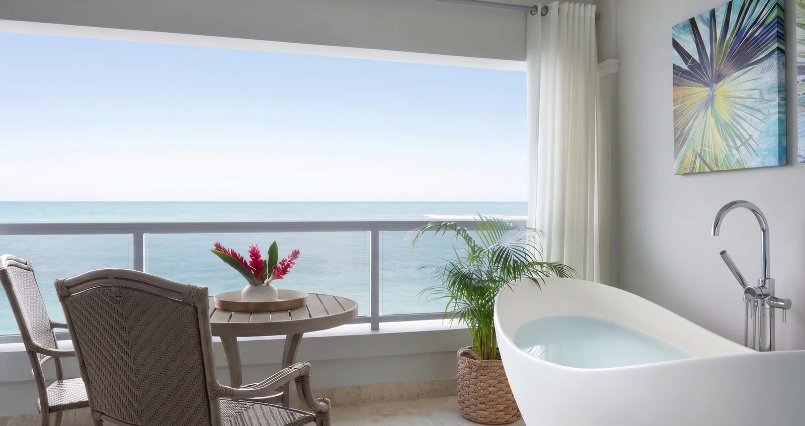 Official image: a balcony with a soaking tub and 2 chairs facing the open sea.