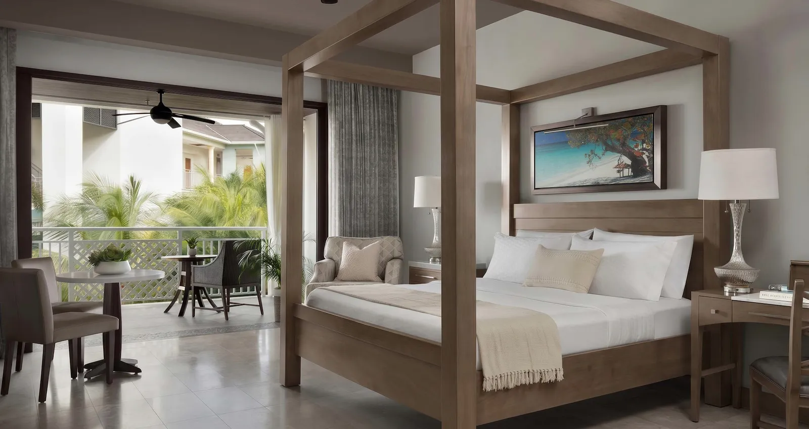Official image: a suite with a four-poster bed, open to a balcony with a table and chairs.