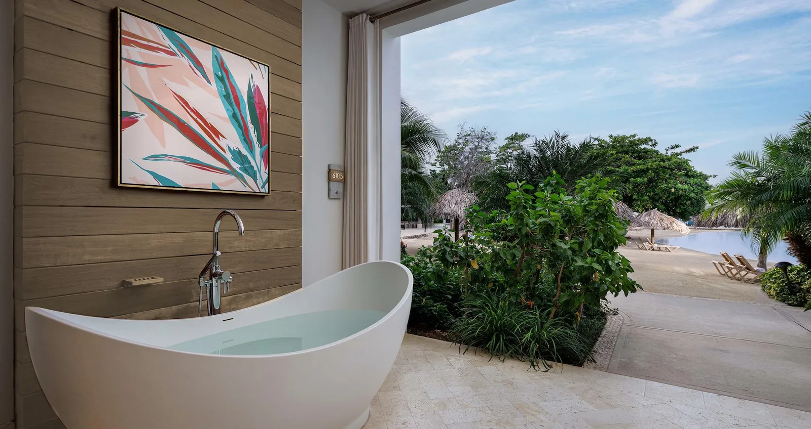 Official image: the soaking tub before a wall open to the beach.