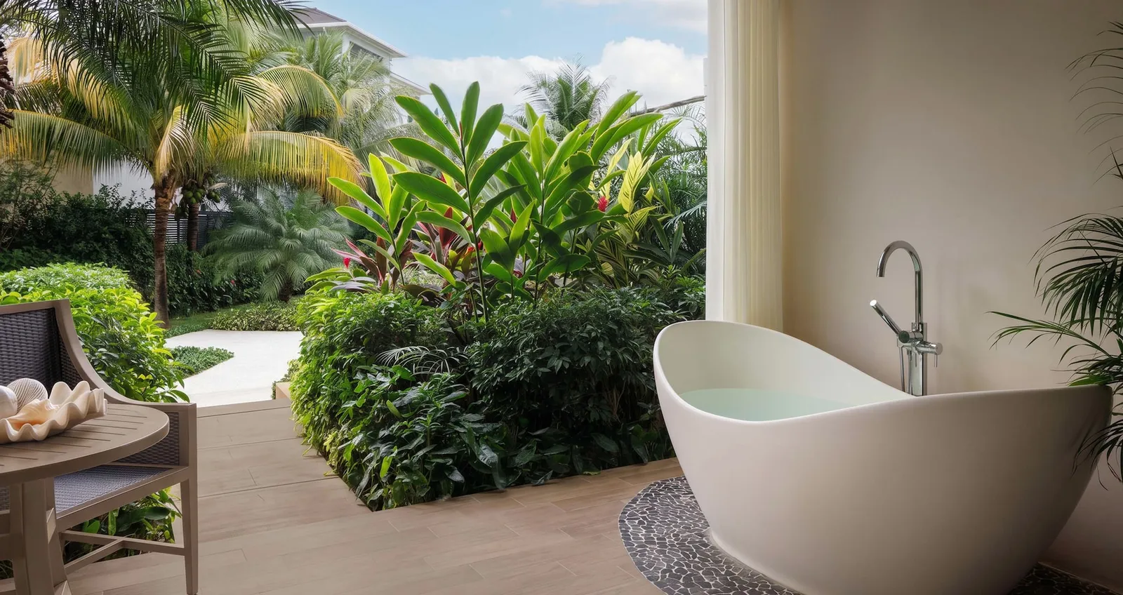 Official image: the soaking tub at the edge of the patio, among the garden’s plants.