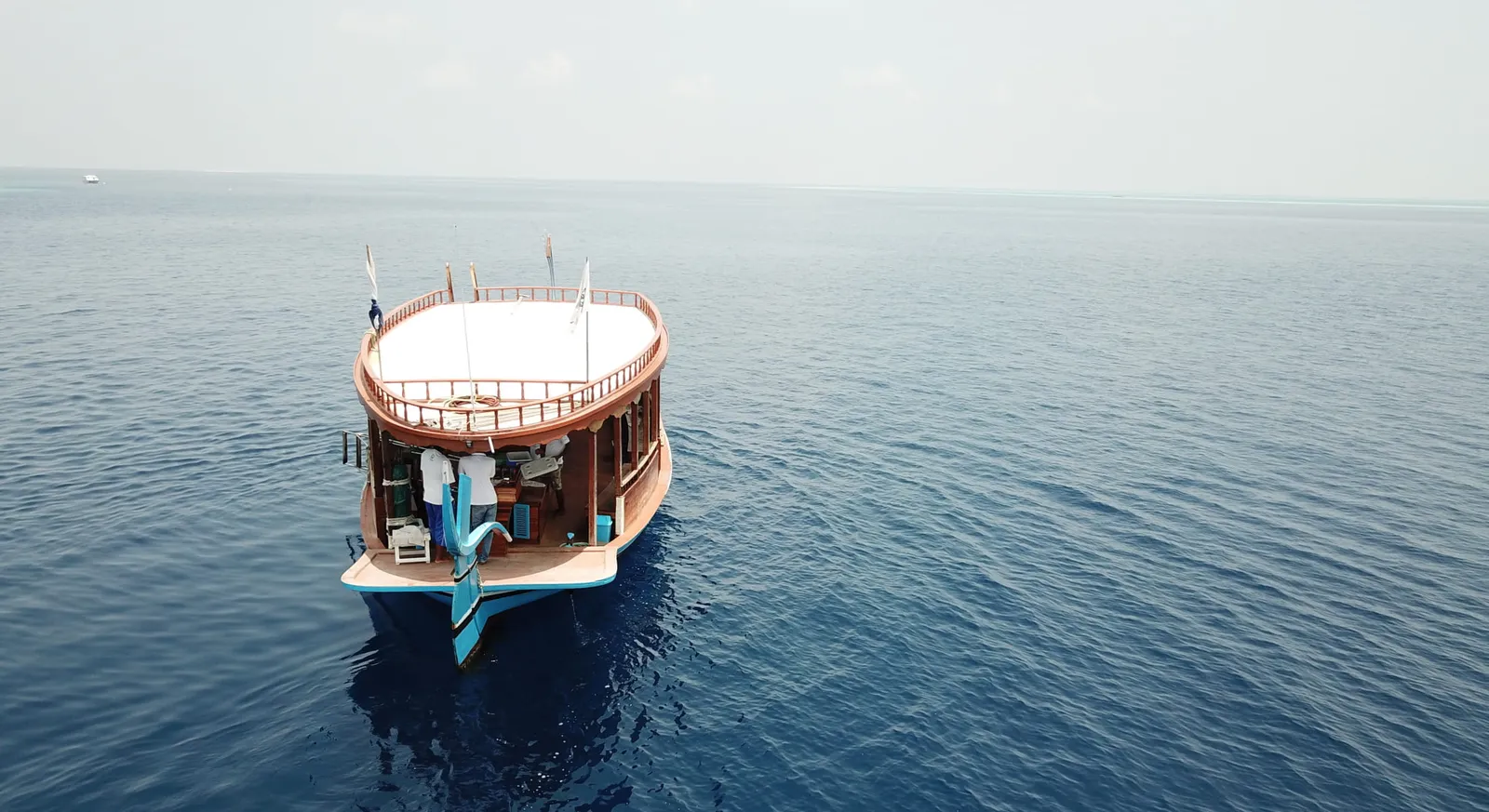 A dhoni, the traditional Maldivian boat, seen from above on a calm sea.