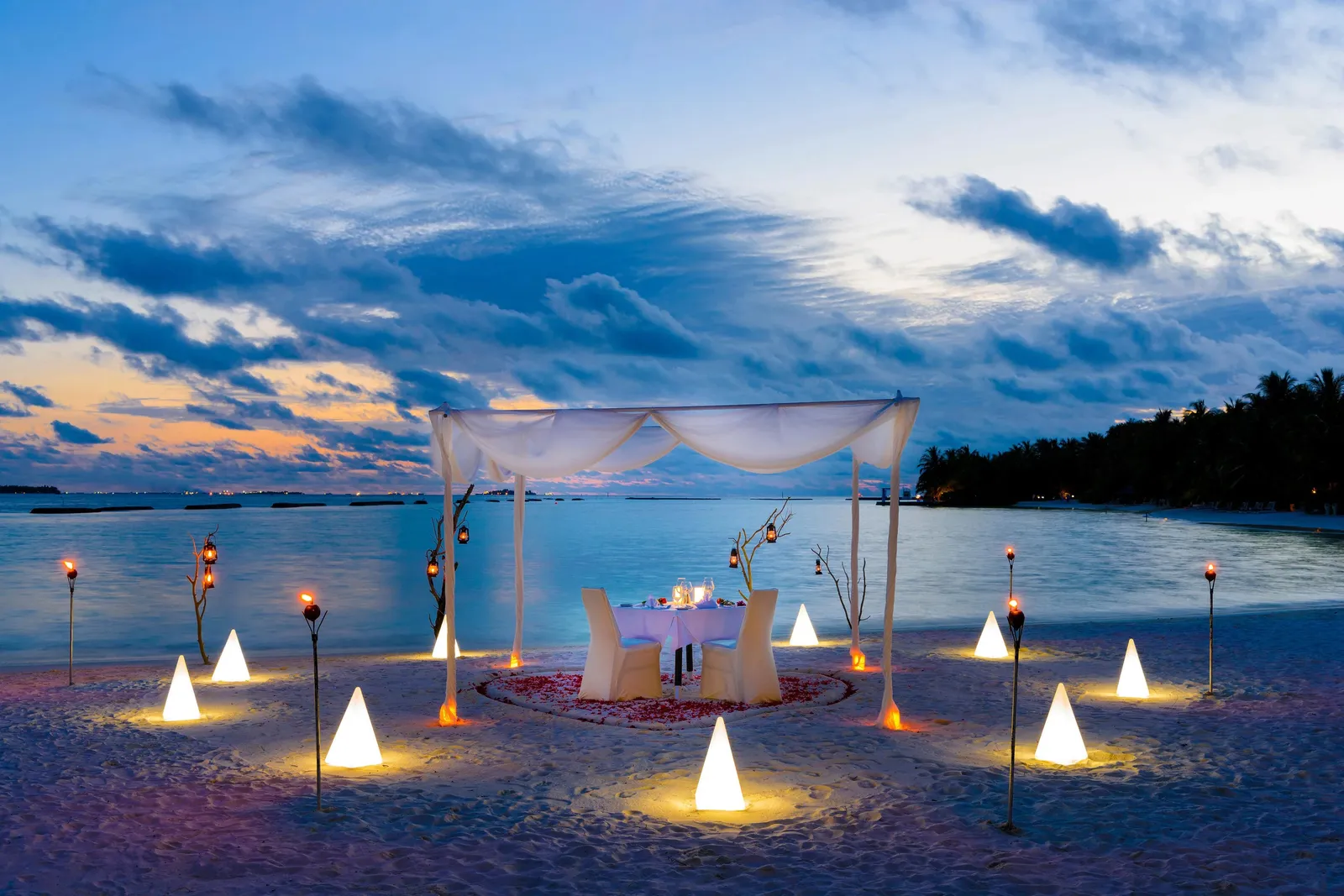 Dinner for 2 on the beach at dusk, under a white canopy among lanterns