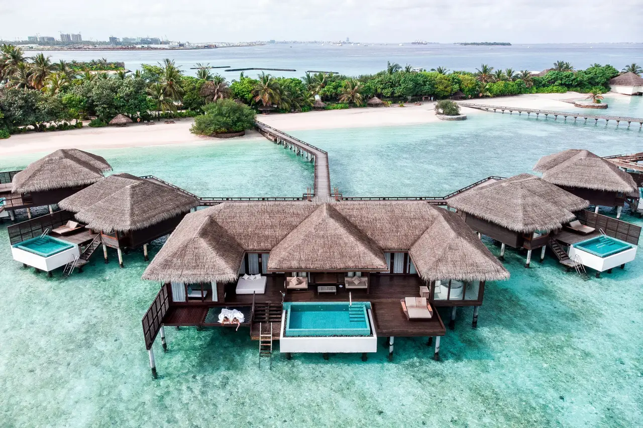 Water villas with plunge pools off the island, and tower blocks on the horizon