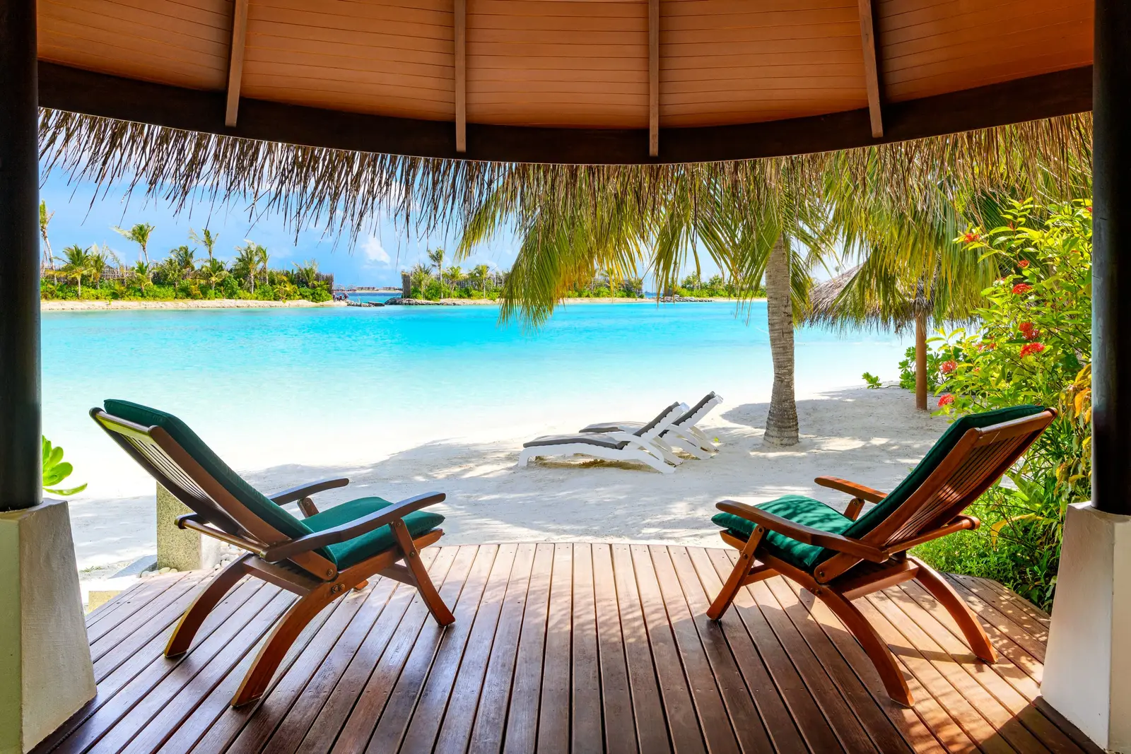 A Beachfront Cottage’s veranda, 2 deckchairs and the beach ahead