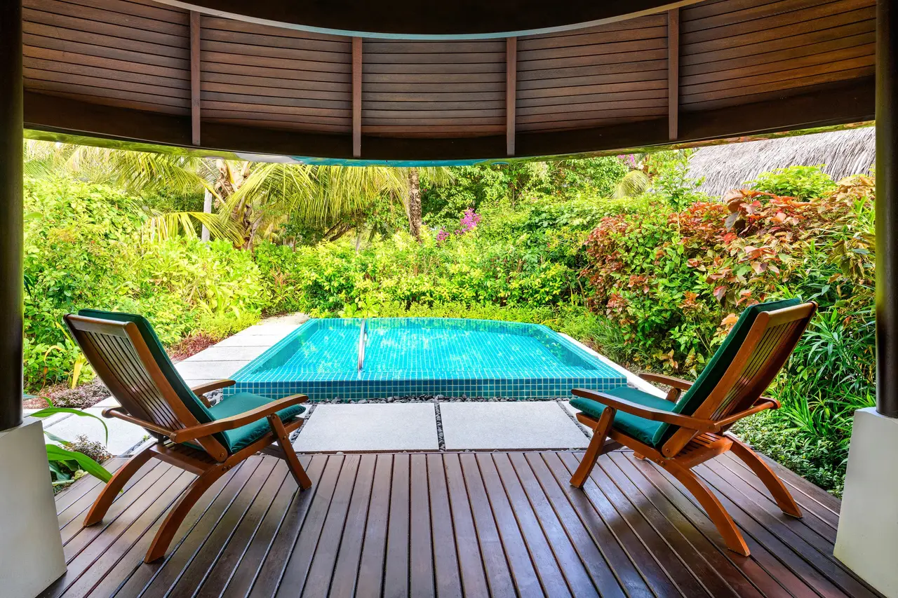 A Cottage with Pool’s veranda, deckchairs and the pool in the garden