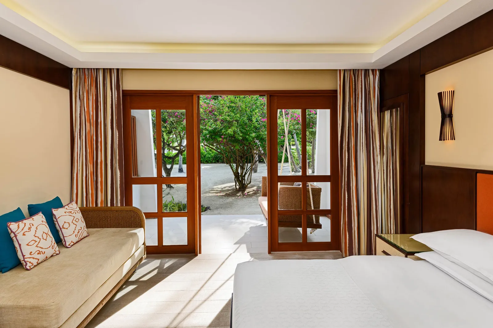 A Deluxe Guest Room, the bed and the sofa, French doors to the garden