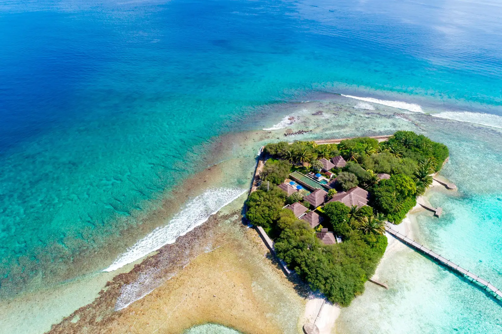 The Shine Spa islet from the air, between the reef and the lagoon, with the bridge to the resort