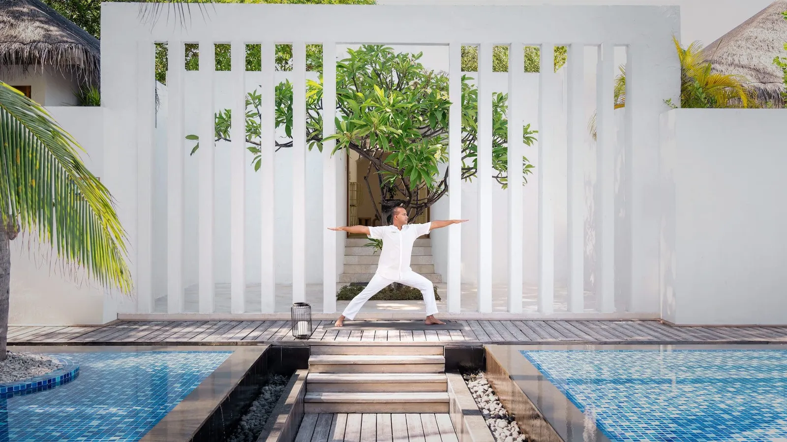 An instructor doing yoga on the deck between the 2 basins of the spa’s adults-only pool.