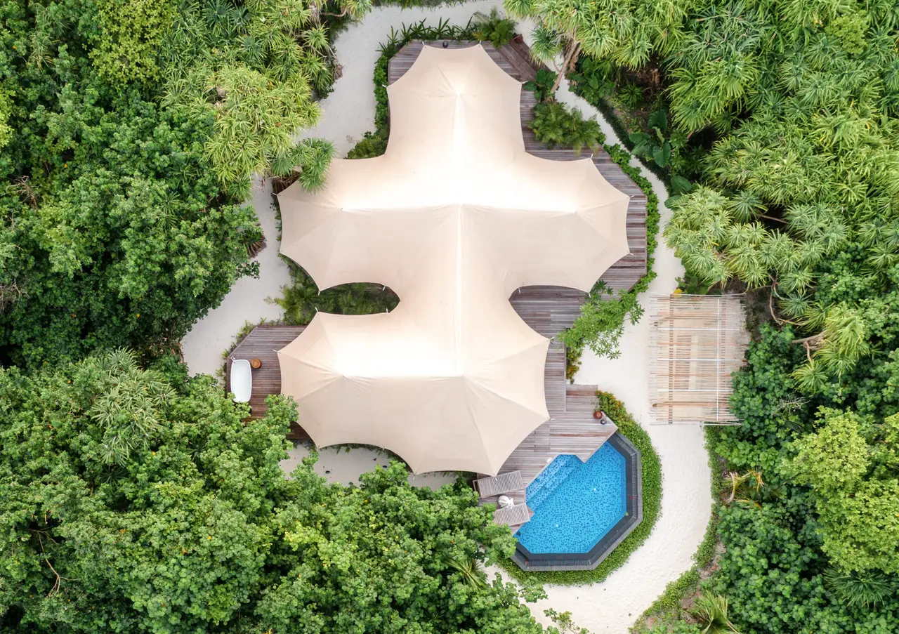 A Safari Tented Jungle Villa from above: the white tent in the jungle and the blue pool beside it.