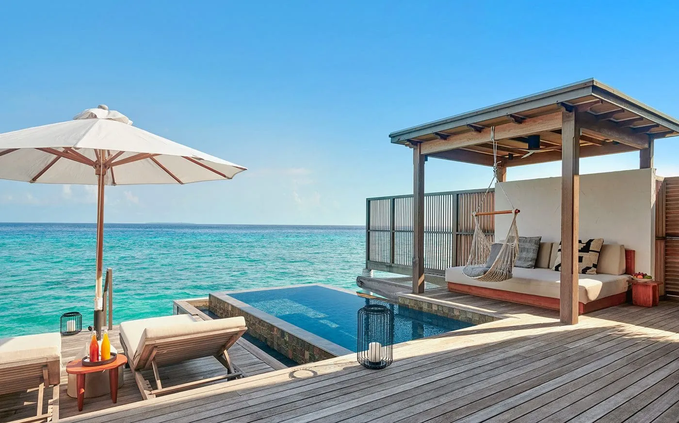 A Sunrise Water Villa’s deck: the infinity pool over the sea, the hammock and a parasol.