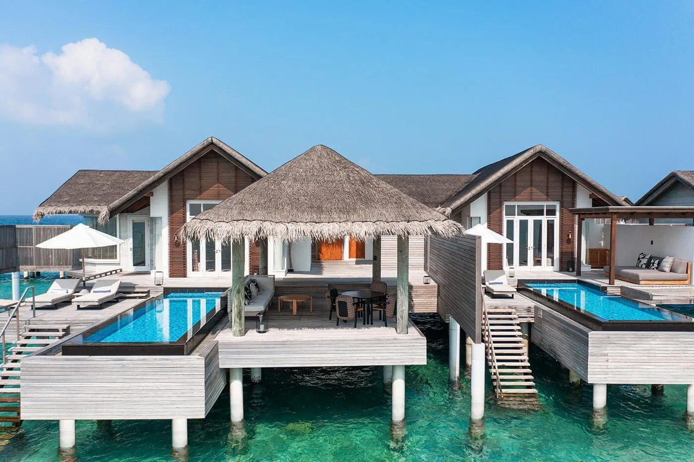 2 Bedroom Sunset Water Villas seen from the sea, with their 2 pools and ladders down to the lagoon.