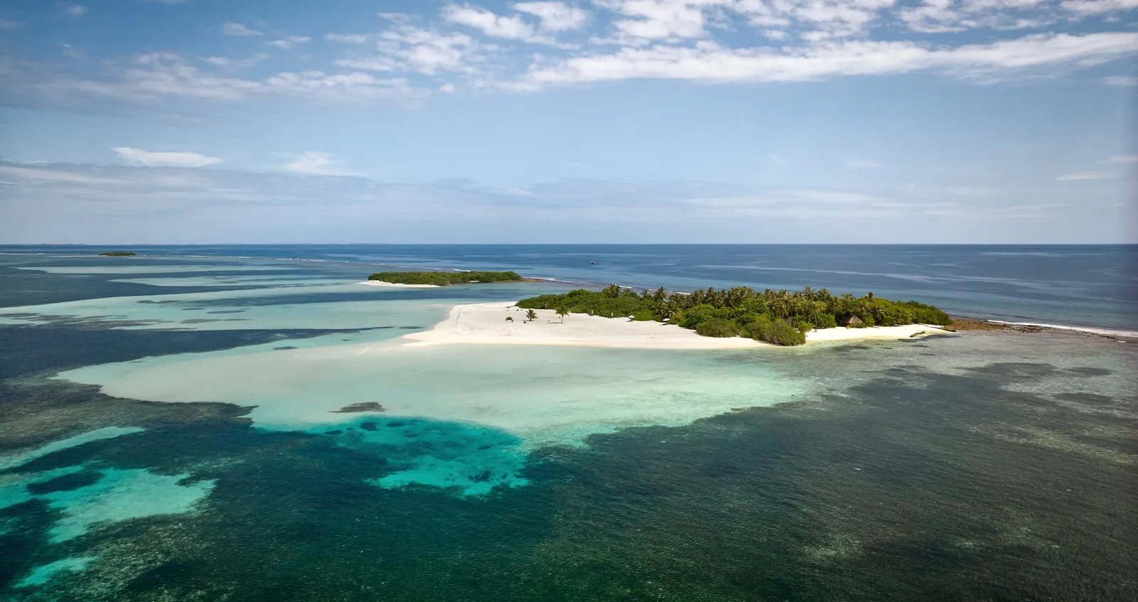 Jehunuhura from the air: an islet of palms and white sand in the middle of the lagoon