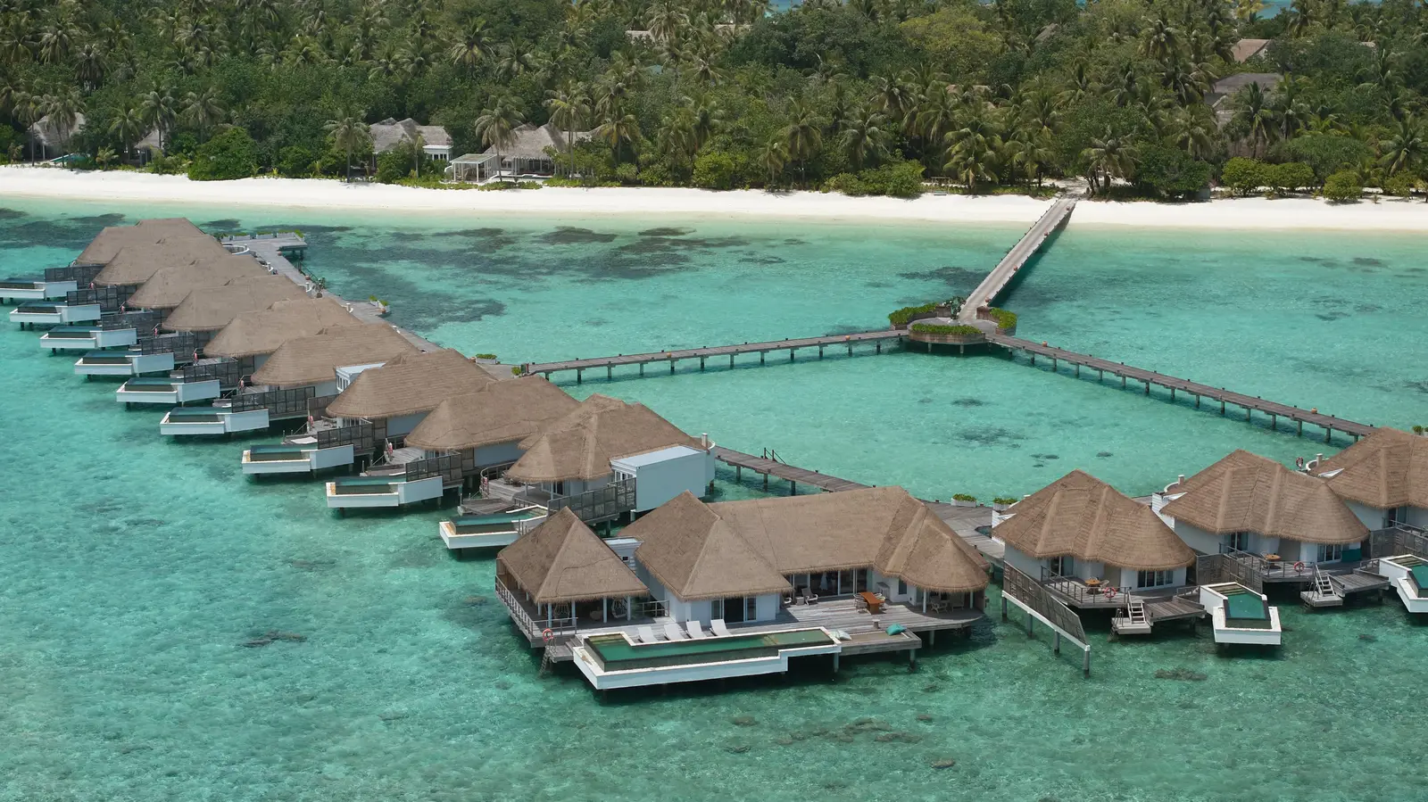 The row of water villas along the jetty, each with its own pool over the lagoon