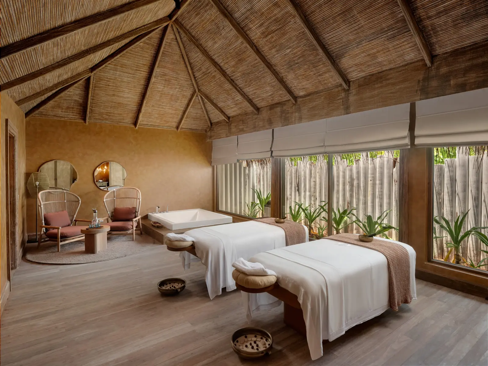 The spa’s couple’s room: 2 massage beds, the timber roof and windows onto the greenery