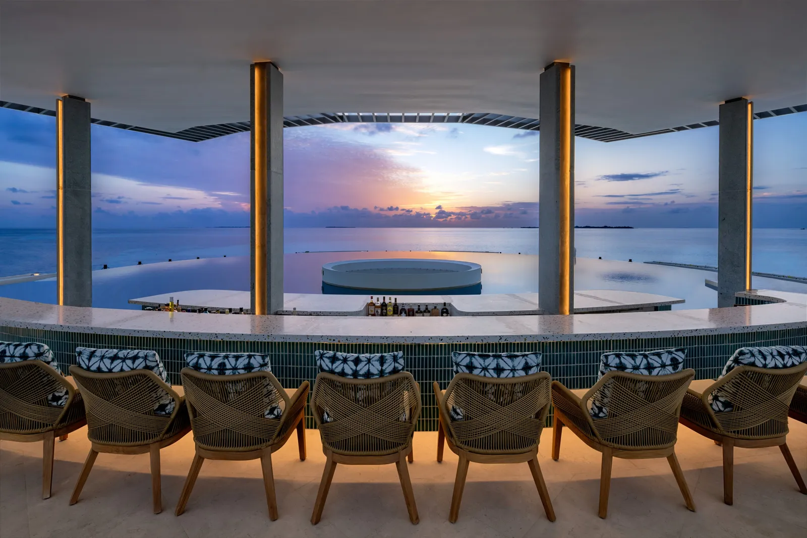 The Sunset Point bar at sunset, the infinity pool and the sea beyond the columns