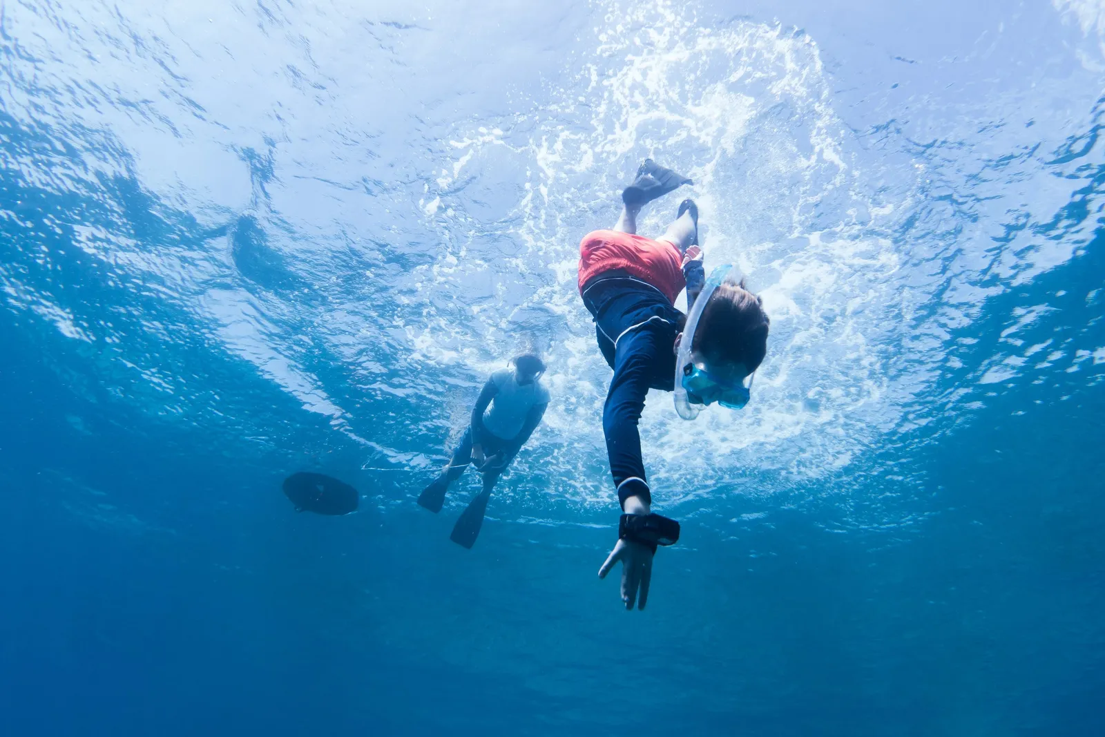 A young snorkeller over the reef with a biologist