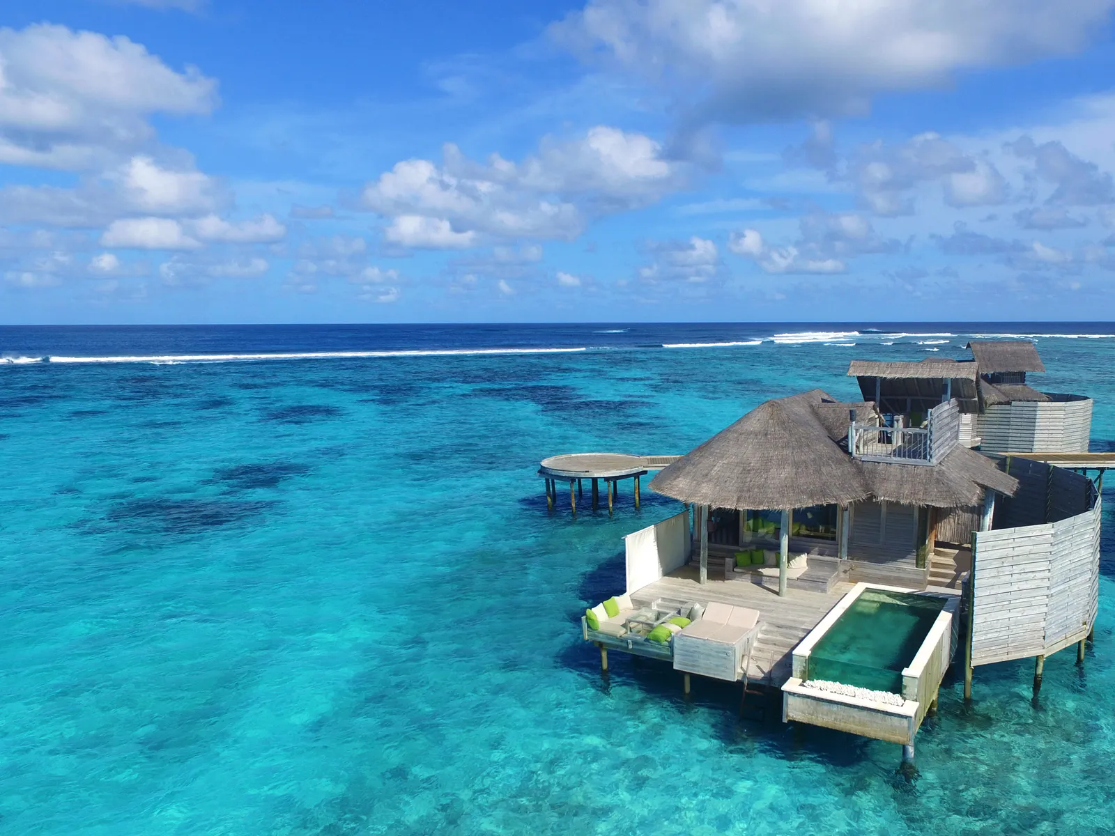 A Laamu Water Villa with Pool seen from above, alone on the water