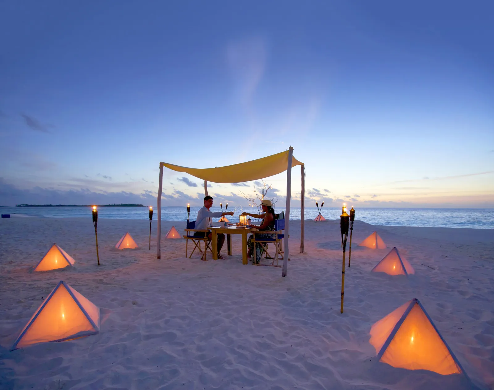 Dinner on the sandbank under a canopy, among lanterns