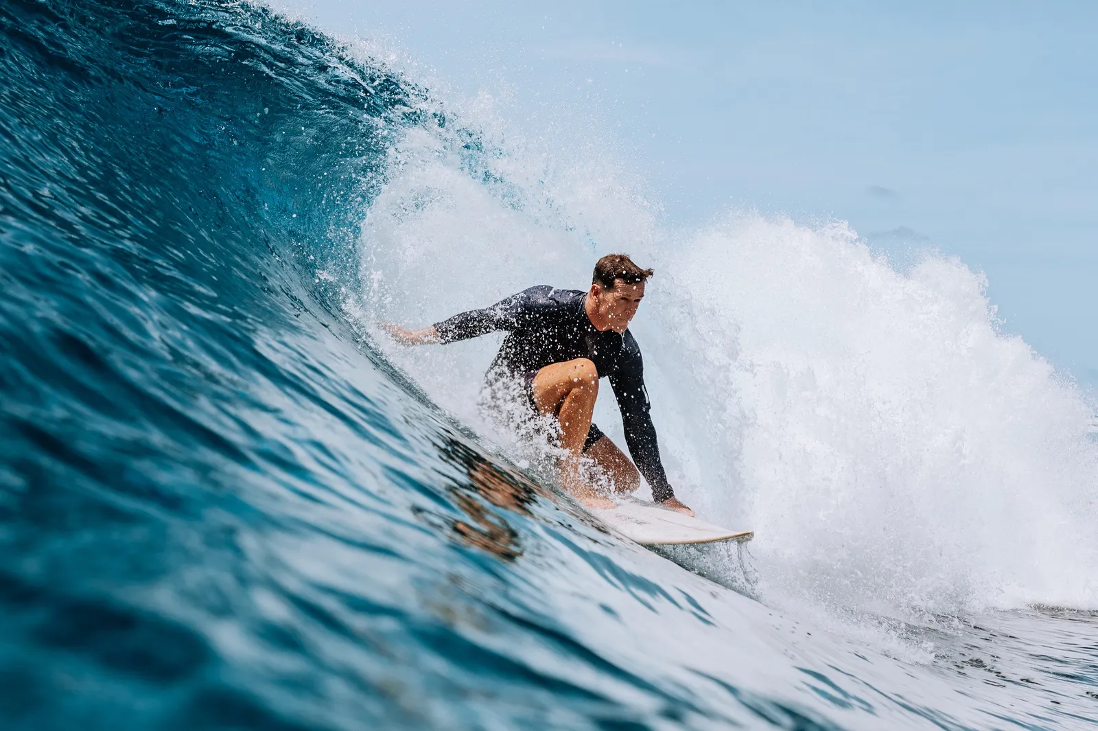 A surfer inside a curling wave in Laamu Atoll