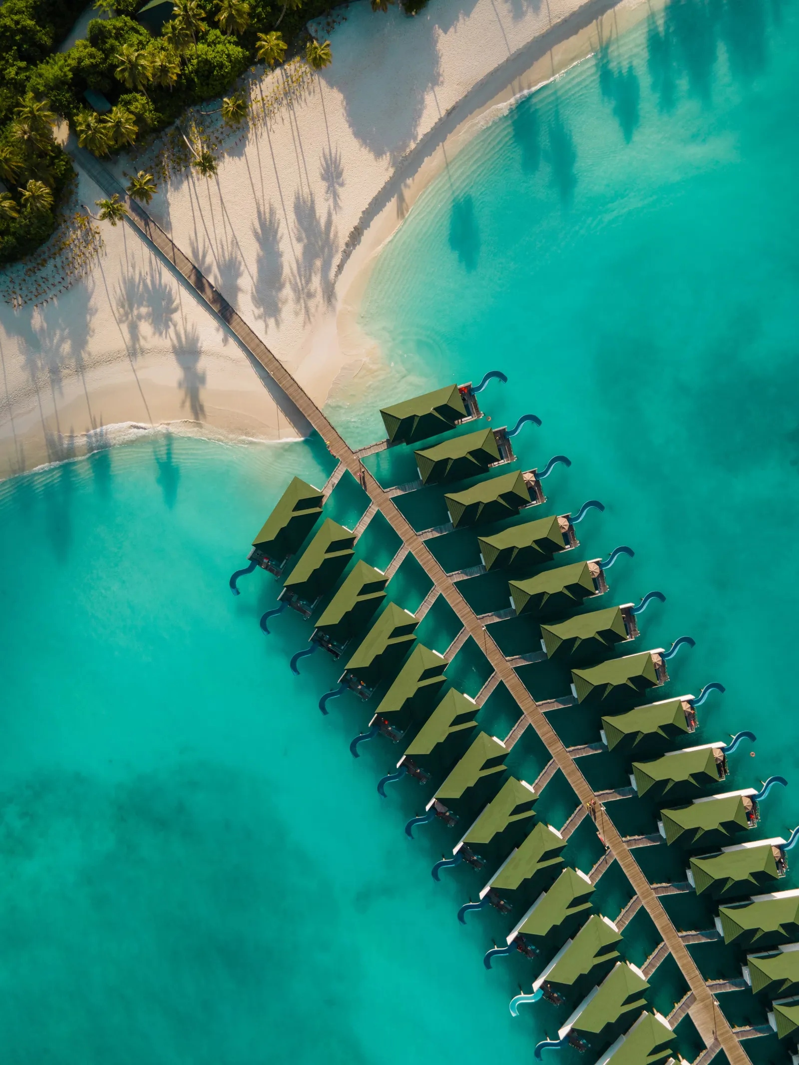 Siyam World from the air: the long row of overwater villas on the turquoise lagoon and the island’s shore