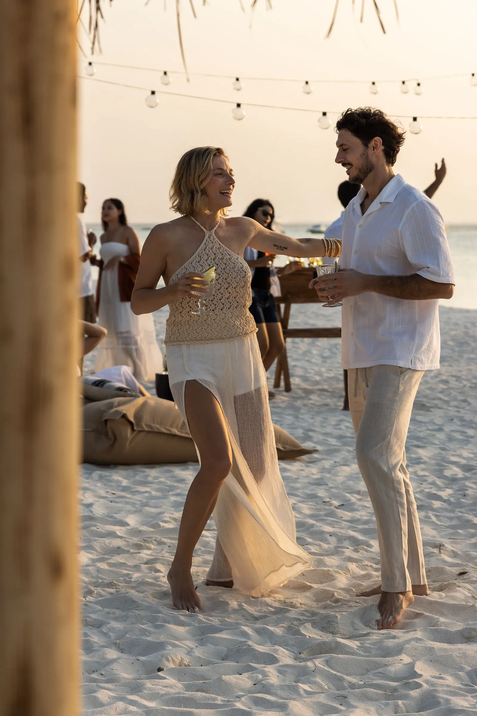 A couple dancing on the sand at a party