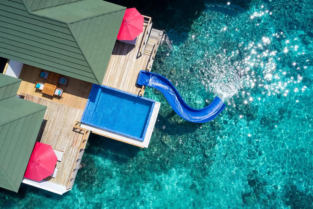 A Two Bedroom Lagoon Villa from above, its pool and the slide splashing down