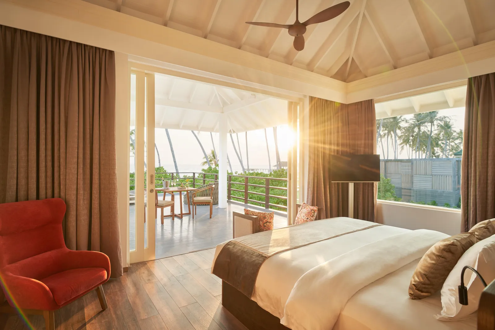 The Two Bedroom Beach Residence bedroom, its bed and sunlit sitting area