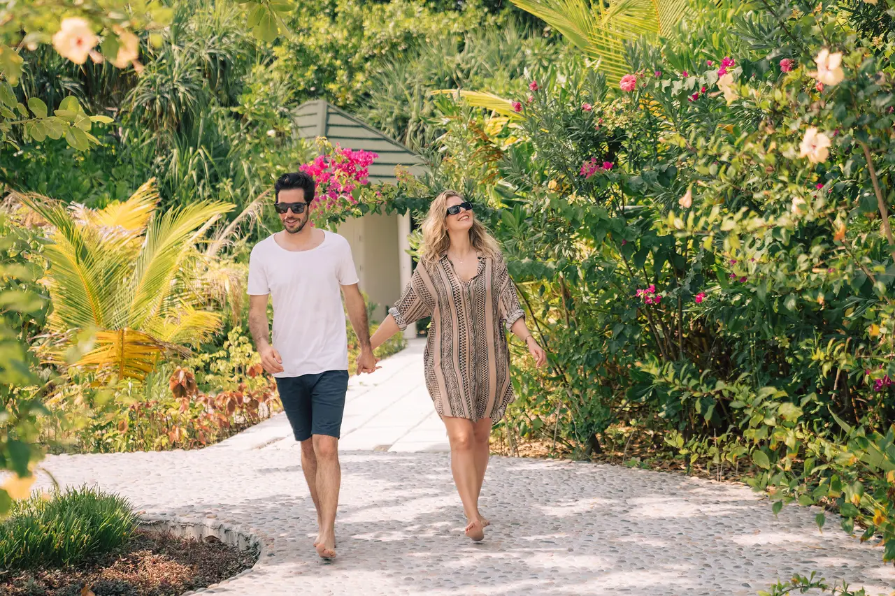 A couple walking through Veyo Spa’s garden, among the flowers
