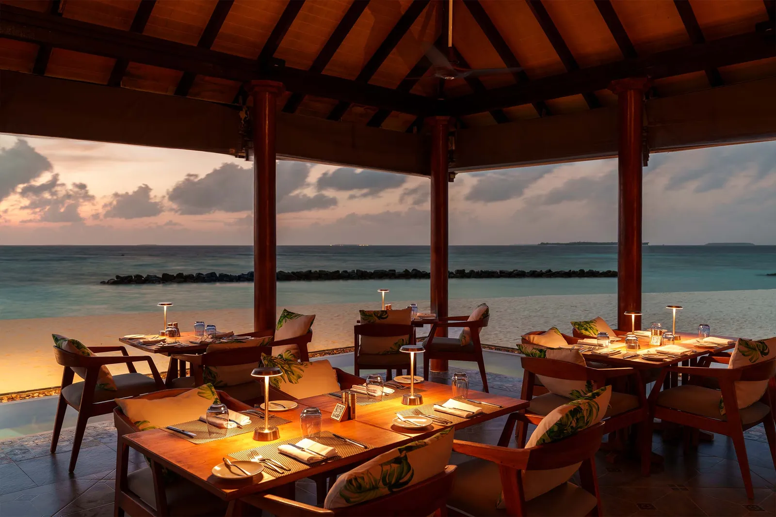 The Wahoo Grill at sunset, tables laid under the roof
