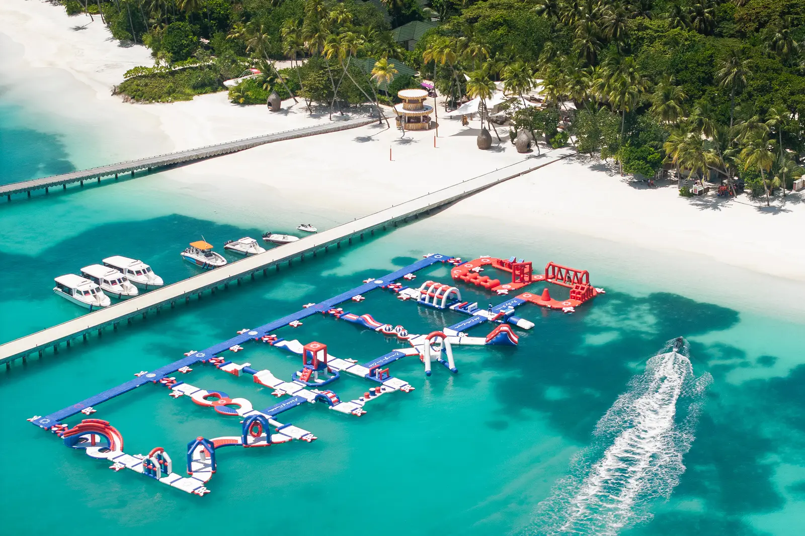 The floating water park from above, its inflatable slides and courses beside the jetty