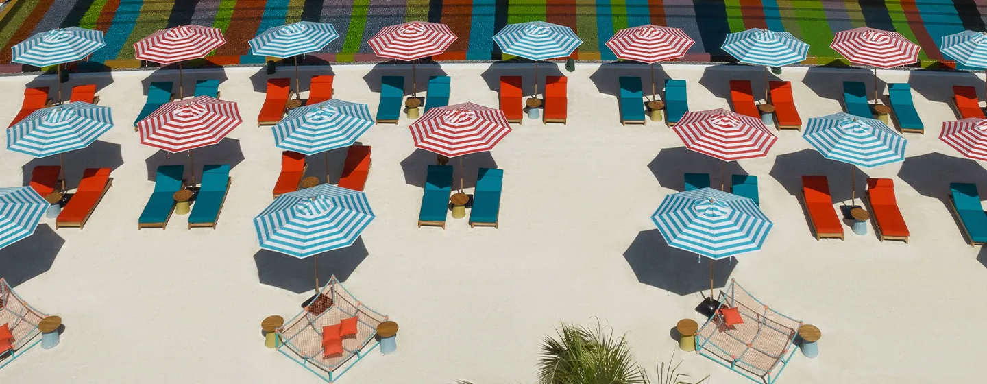 Striped parasols and coloured loungers on Lazuli’s sand.
