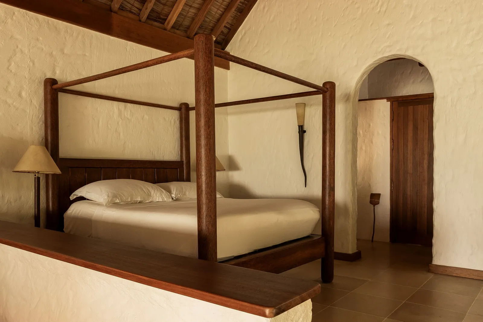 Soneva Fushi Villa Suite: the four-poster bed between white walls