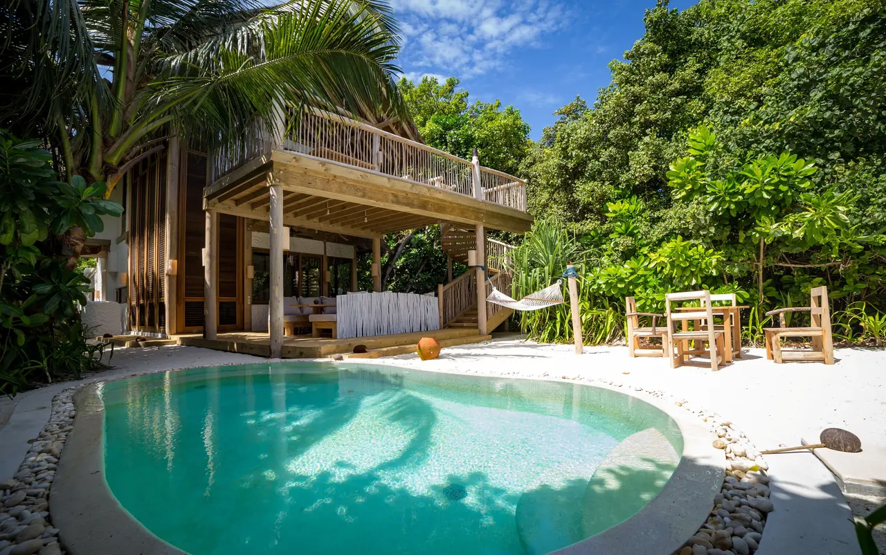 2 Bedroom Crusoe Suite: the pool, the loungers and the 2-storey house among the trees