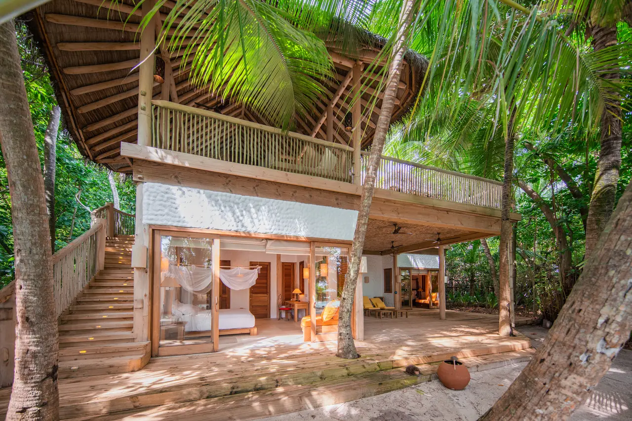 A 3-bedroom beach villa: the staircase and open living room among the palms