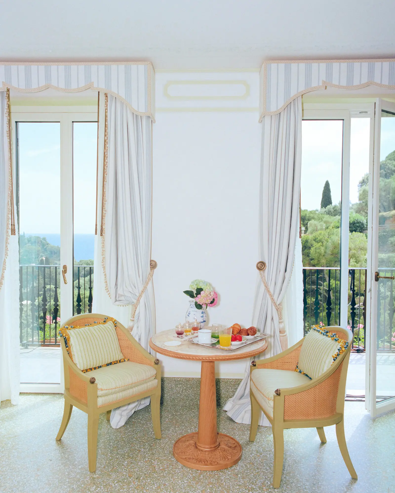 Breakfast in the room on a round table between 2 armchairs, before the French windows onto the balcony.