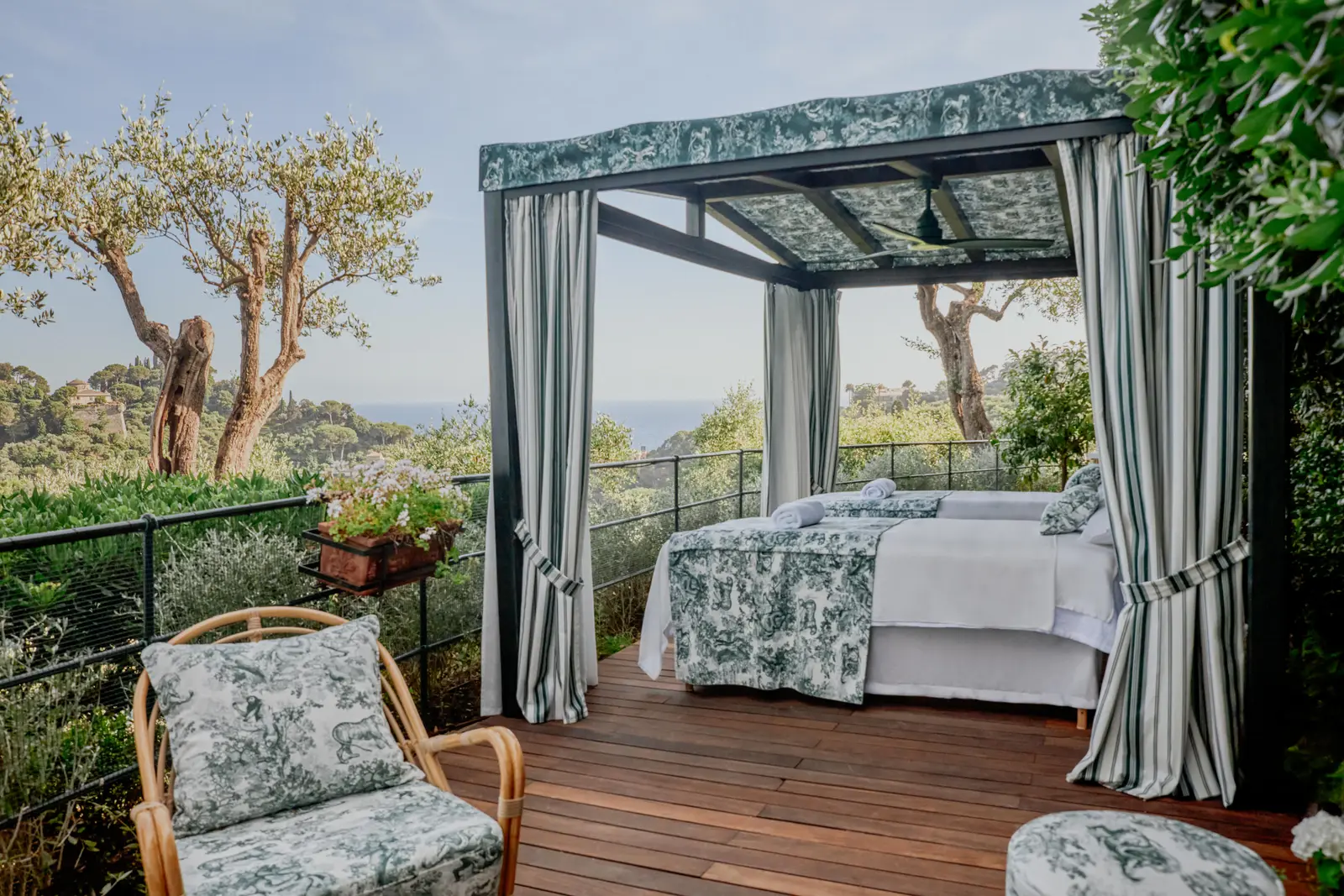 A Dior Spa gazebo in the garden: the treatment bed between toile de Jouy curtains, olive trees and the sea beyond.