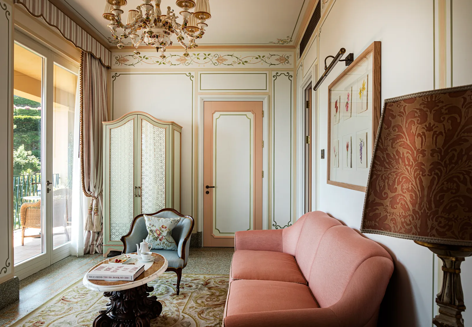 The Baronessa Suite’s sitting room: the pink sofa, an antique armchair, the painted wardrobe and the French window onto the terrace.