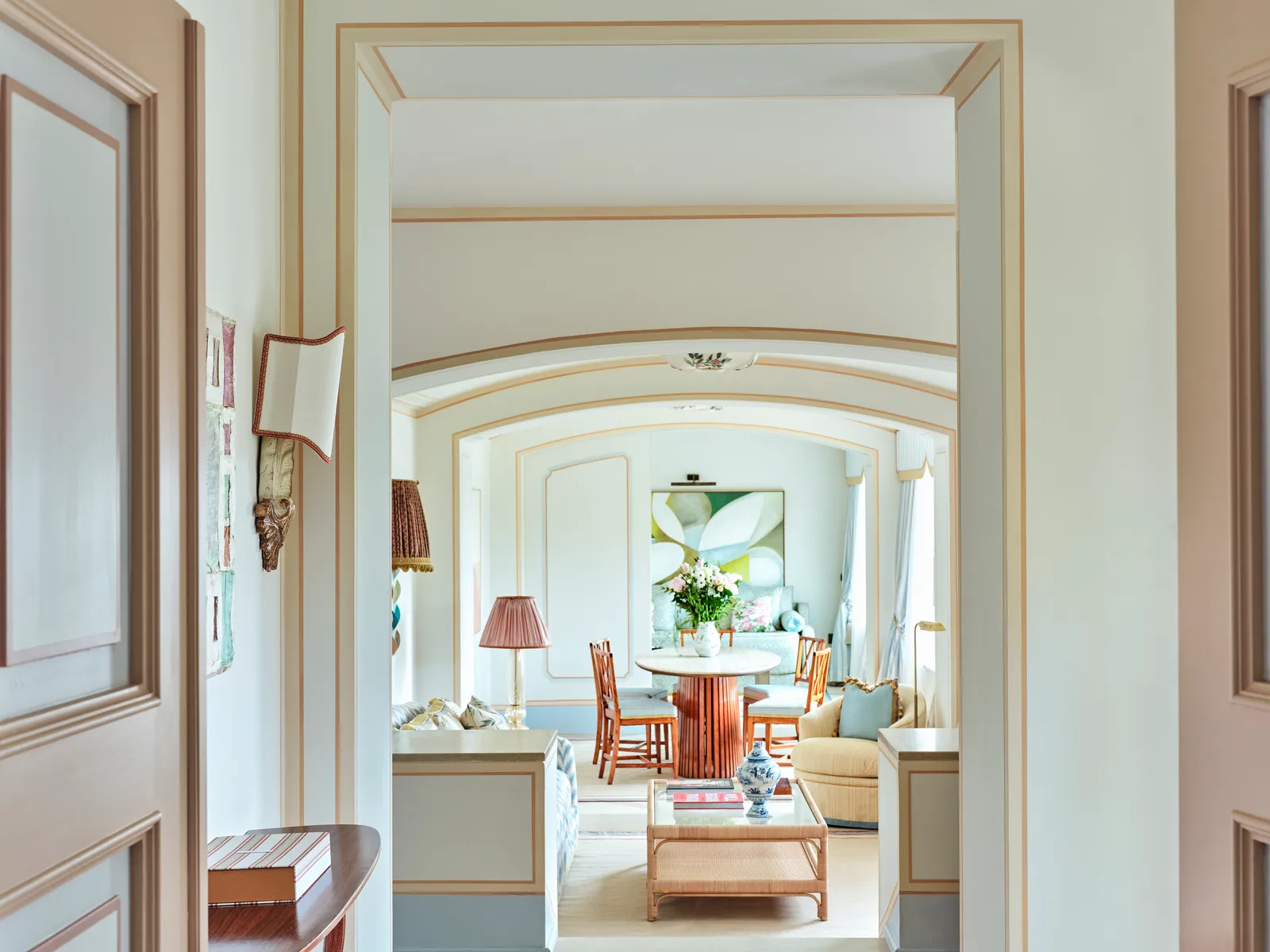 La Dolce Vita Suite from its entrance: beyond the arch, the living room with the round dining table and sofas.