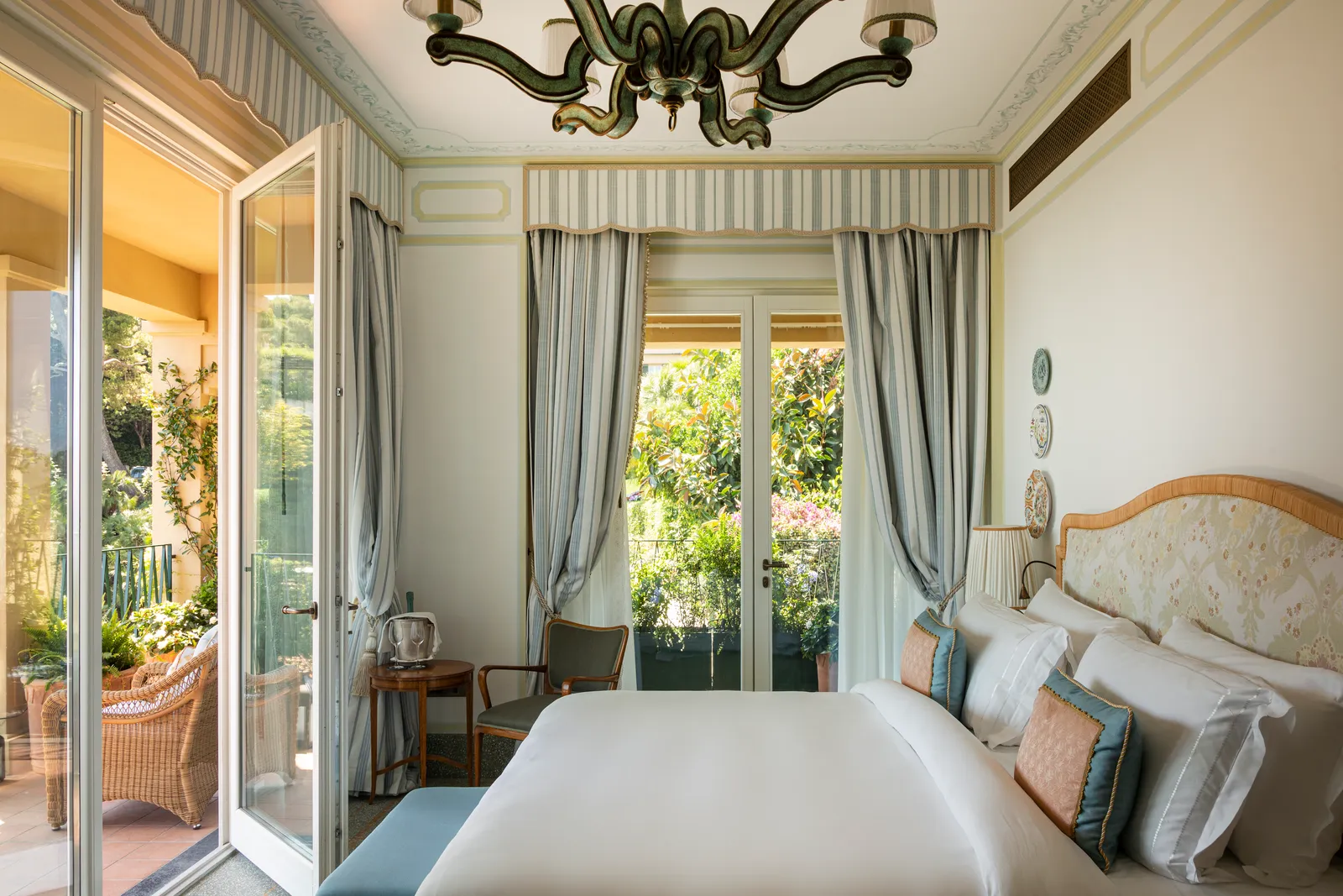 A Premium Room with French windows open on 2 sides, onto the terrace and the greenery.